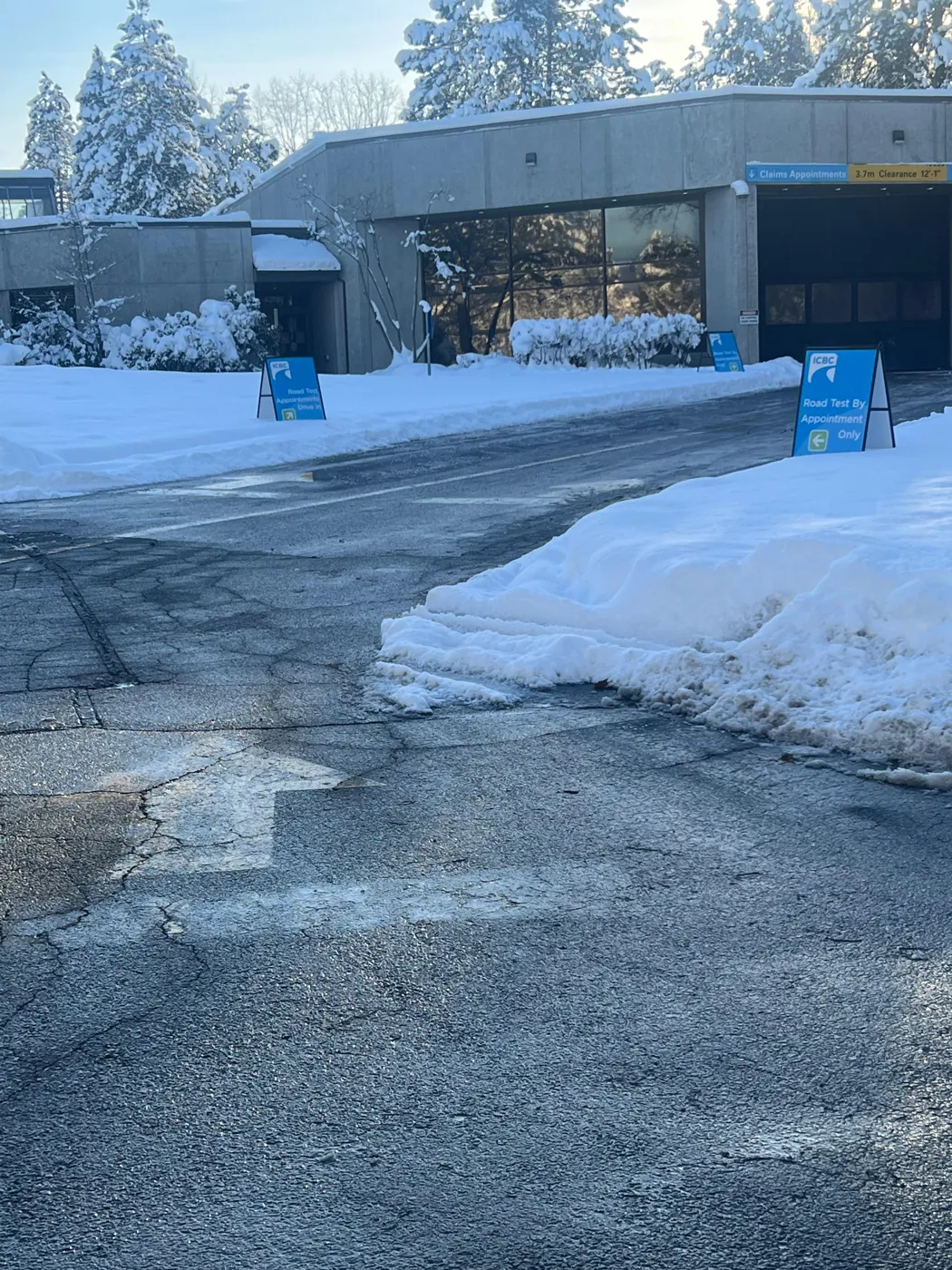 Vehicle approach at an ICBC claim centre with snow piled along the edges